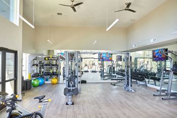 A spacious gym with a variety of equipment and a bicycle.